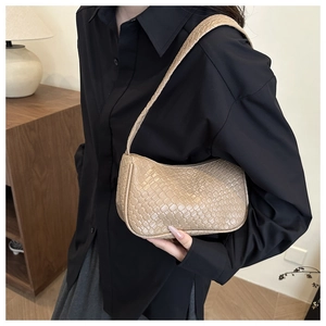 Detail shot of the beige woven baguette bag with intricate cross-weave texture