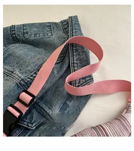 Gros plan sur la bandoulière en nylon rose avec boucles en plastique noir pour sac poitrine