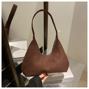 Détail d'un sac hobo vintage en daim marron avec fermeture éclair et finition mate
