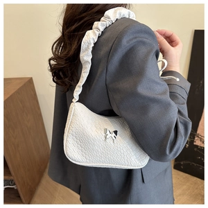 Vue détaillée du sac blanc effet crocodile avec papillon argenté et bandoulière plissée