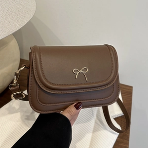 Chic brown matte leather underarm bag with gold bow detail and adjustable shoulder strap