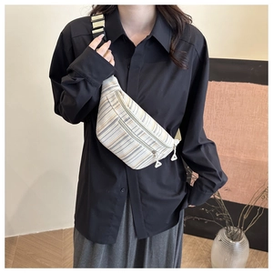 Détail du sac de poitrine en toile rayée avec sangle réglable et double fermeture éclair