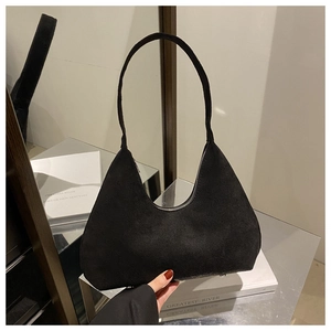 Détail d'un sac hobo en daim noir avec fermeture éclair sur un support de miroir chic
