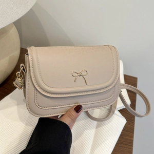 Chic beige underarm bag for women with gold bow buckle in a trendy minimalist style