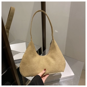 Détail du sac hobo en daim kaki avec fermeture éclair et texture vintage élégante