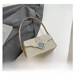 Detail shot of the woven beige crossbody bag featuring a geometric metal buckle
