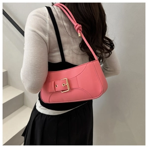 Dettaglio borsa sottobraccio in pelle rosa opaca con fibbia oro su modella, sfondo bianco