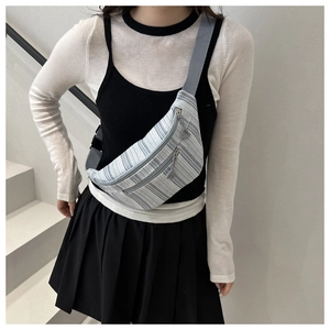 Détail du sac de poitrine rayé bleu avec bandoulière réglable et double fermeture éclair