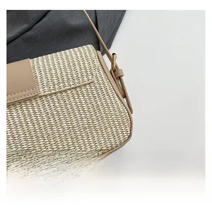 Detail of straw woven texture with light leather flap and golden metal clasp on handbag