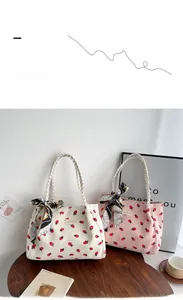 Detail of strawberry print tote bags with woven handles and decorative scarves