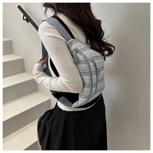 Détail du sac de poitrine rayé à double fermeture éclair porté par un mannequin