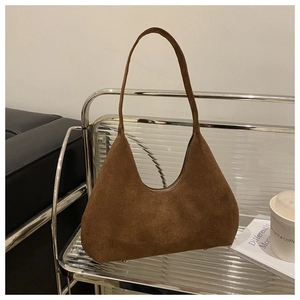 Vue détaillée du sac d'épaule en daim marron avec design arc rétro sur une étagère