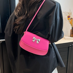 Hot pink shoulder bag featuring a metallic silver bow clasp and thin matching strap