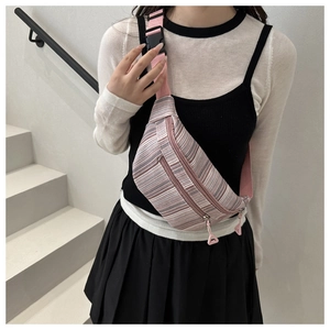 Détail du sac banane en toile à rayures avec sangles roses et deux poches zippées