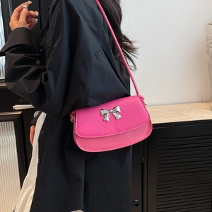 Shoulder bag in rose pink featuring a metallic silver bow accent and slim strap