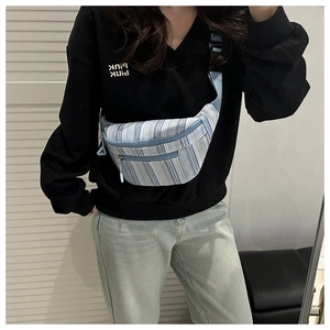 Détail d'un sac de poitrine en toile à rayures bleues et blanches avec sangle réglable