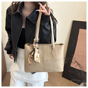 Detail of khaki patchwork tote bag with snakeskin texture and decorative floral silk scarf