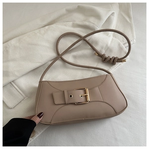 Dettaglio della borsa a tracolla beige in ecopelle con grande fibbia dorata decorativa