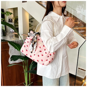 Detail of pink corduroy tote bag featuring strawberry prints and woven rope handles