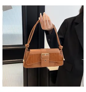 Close-up of vintage brown underarm bag with crocodile pattern and metal buckle detail
