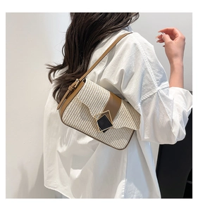 Detail of cream woven texture and brown leather flap on a stylish women's shoulder bag