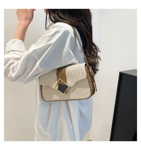 Detail of a chic woven shoulder bag with brown leather trim and metallic buckle