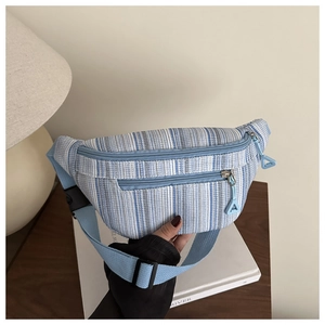 Détail d'un sac de poitrine tissé à rayures bleues et blanches avec bandoulière réglable