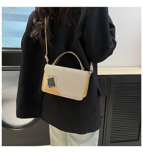 Dettaglio borsa a tracolla glitter oro champagne con moderna fibbia quadrata nera e oro