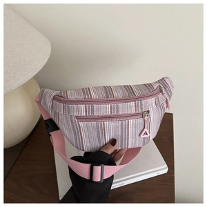 Détail du sac de poitrine en toile à rayures roses et blanches avec sangle réglable