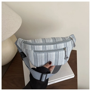 Détail du sac banane en toile à rayures bleues et blanches avec double fermeture éclair