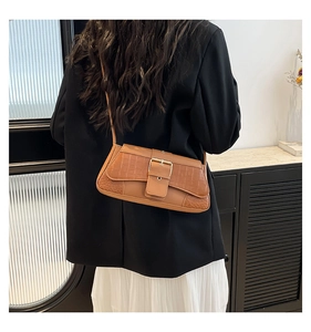 Detail of crocodile pattern crossbody bag showing back view on shoulder
