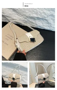 Detail of straw-woven shoulder bag with white leather flap and geometric metal buckle