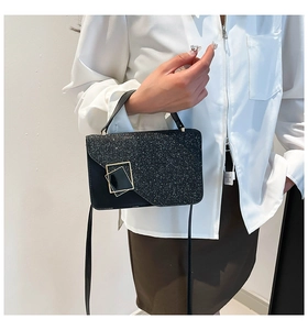 Detailopname van zwarte pailletten crossbodytas met een zilveren metalen vierkante gesp