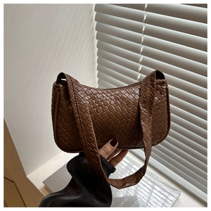 Close-up of brown woven baguette bag texture with soft natural window shadows