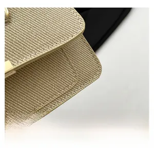 Detail shot of light brown woven fabric with white stitching and gold metal buckle
