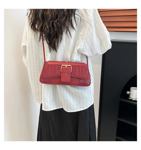 Detail of burgundy crocodile-textured shoulder bag with vintage gold square buckle