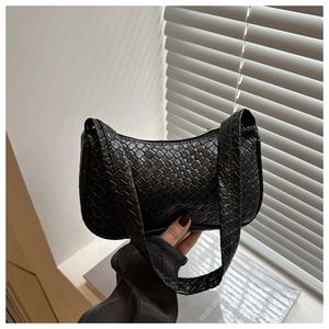 Detail shot of black woven texture leather bag featuring fine checkered craft pattern