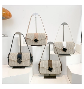 Detail of woven straw shoulder bags featuring wave-edge flaps and four color strap options