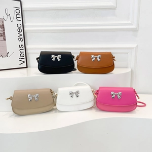 Five colors of minimalist crossbody bags with silver bow accents on wavy display stands