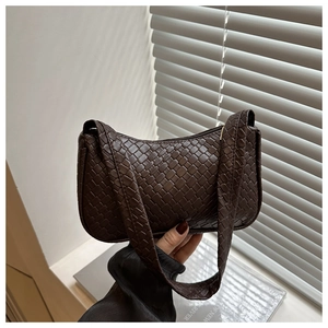 Detail shot of the dark brown woven texture on a minimalist leather baguette bag