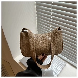 Detail of khaki woven texture and refined synthetic leather on a hobo shoulder bag