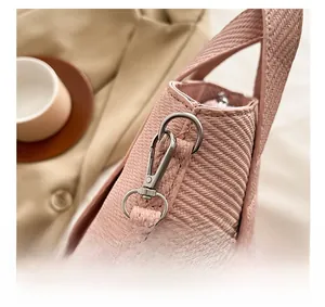 Detailed close-up of the silver metal hook on pink woven luxury tote handbag
