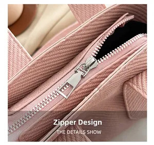 Detail view of the sleek metal zipper on a pink luxury bag with twill fabric texture