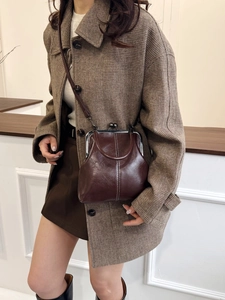 Close-up of vintage brown leather doctor bag with white stitching and metal clasp