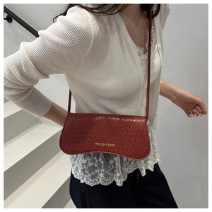 Detail of red-brown crocodile pattern shoulder bag featuring gold Fashion & Bags logo