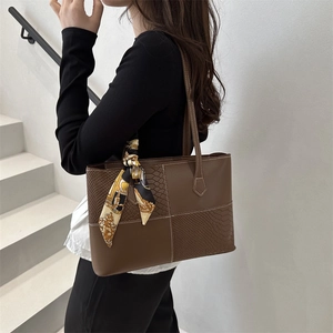 Deep brown tote bag with decorative scarf and snakeskin texture shown on model