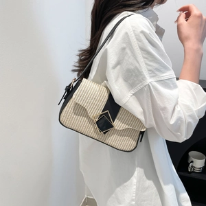 Chic beige woven shoulder bag with black leather trim worn by model in white shirt