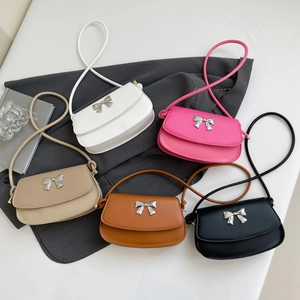 Detailed overhead view of minimalist bow square bags in five colors with silver hardware