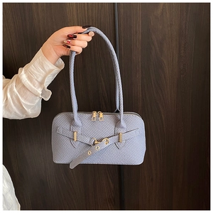 Detail of light blue woven texture shoulder bag with gold buckles and dual zippers