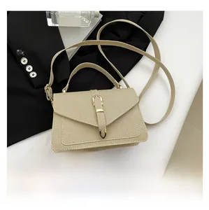 Close-up of light khaki woven texture flap bag with gold buckle and smartphone for scale
